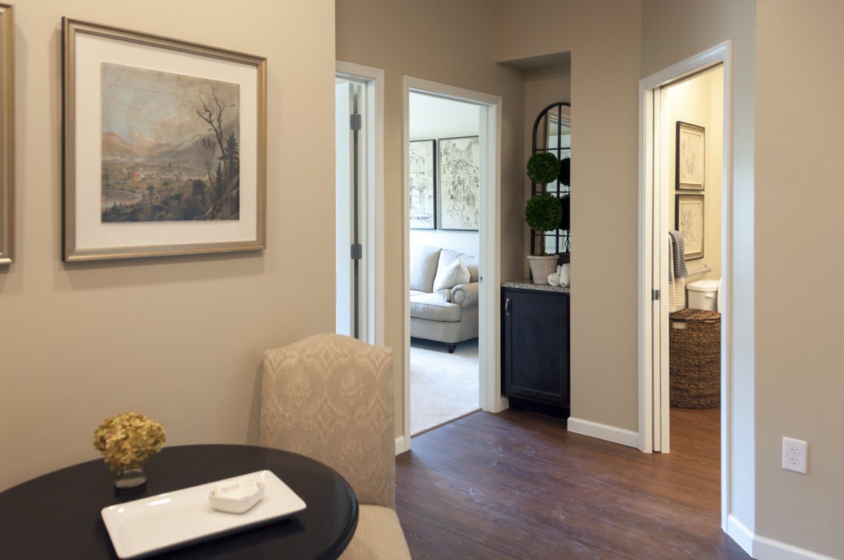 A cozy interior with a dining table, hallway, and glimpses of living areas.