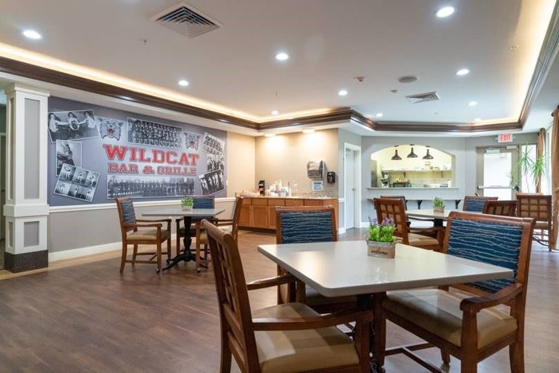 An indoor dining area with tables and chairs, featuring a casual atmosphere and decorative elements.