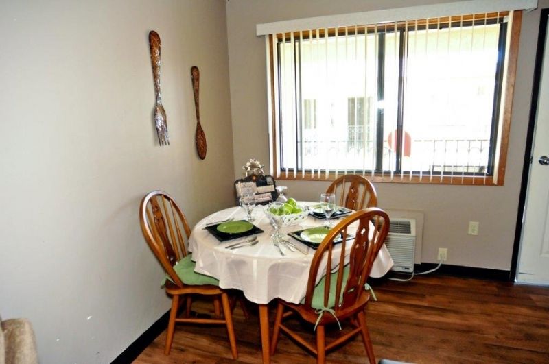 A cozy dining area with a set table for four near a large window.