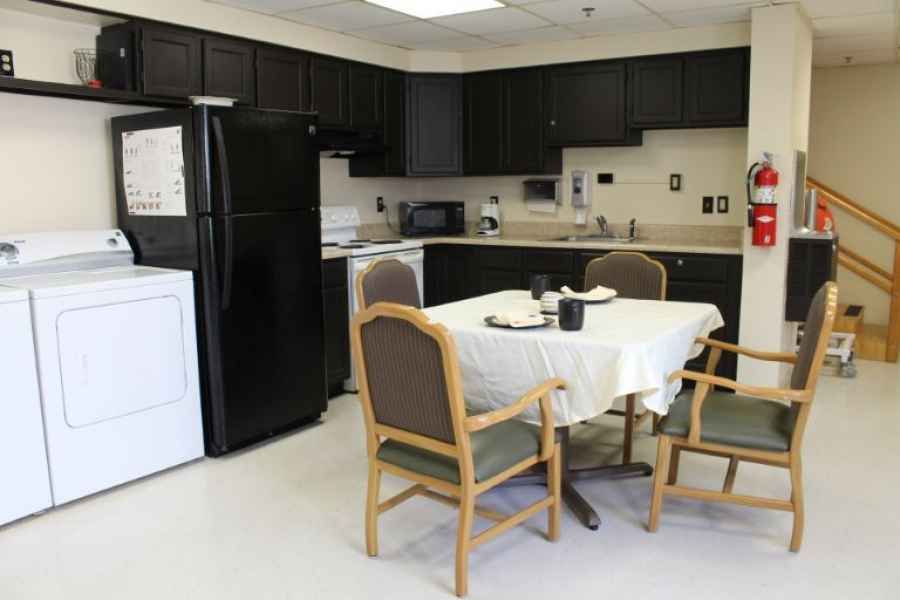 A modern kitchen with a dining area featuring a table and chairs, along with various appliances.