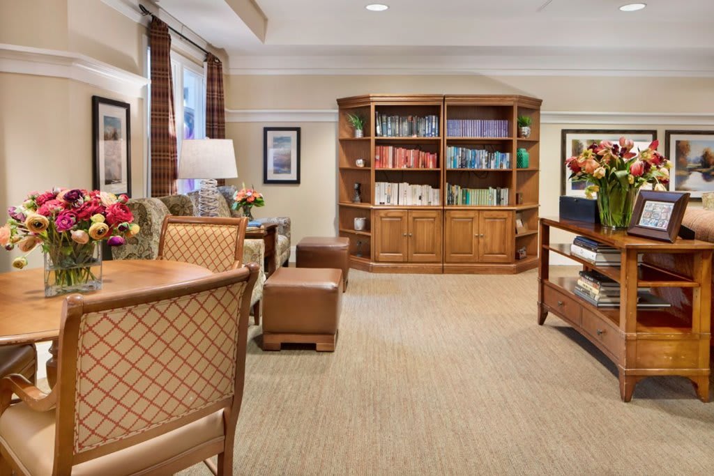 A cozy living room with a bookshelf, comfortable seating, and elegant interior design.