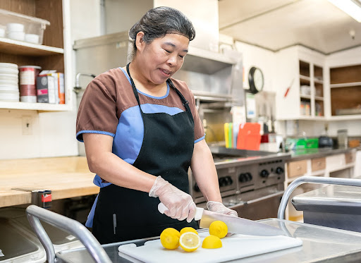 A woman prepares lemons in a kitchen, showcasing the art of food preparation.
