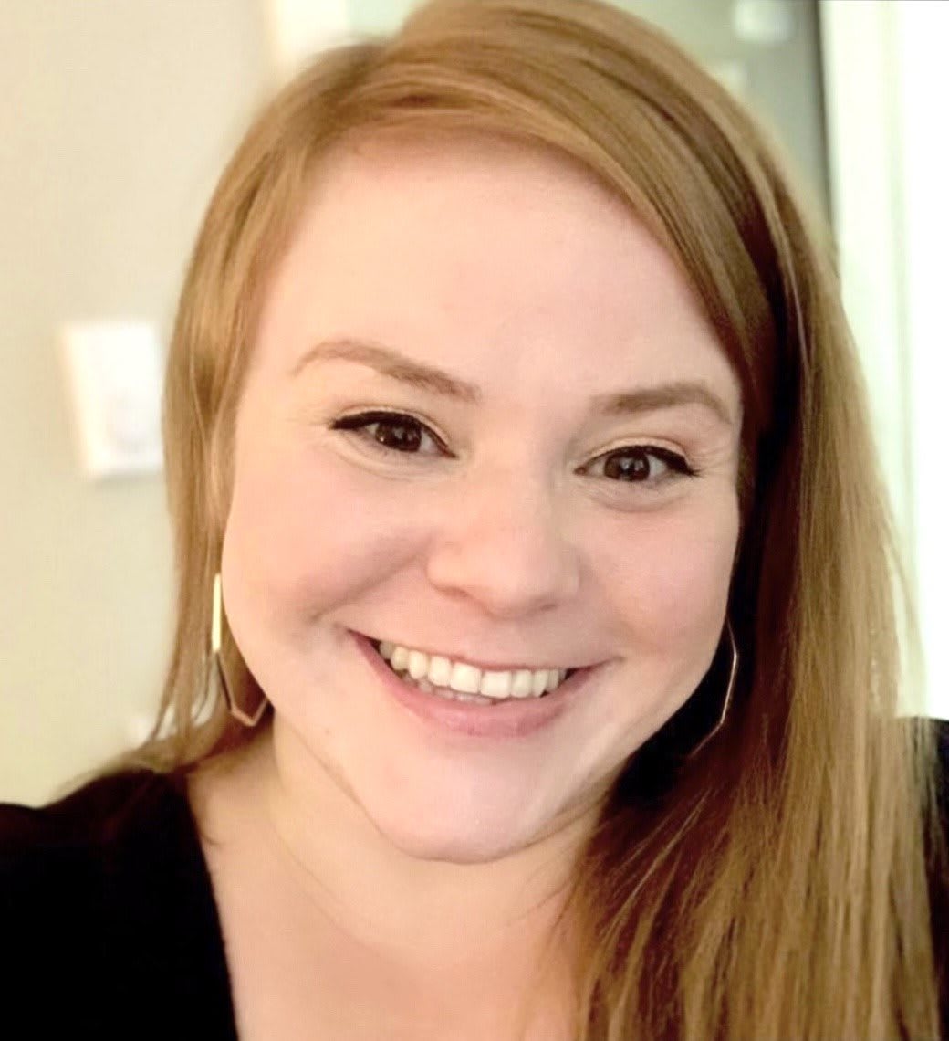 A smiling woman posing for a portrait indoors.
