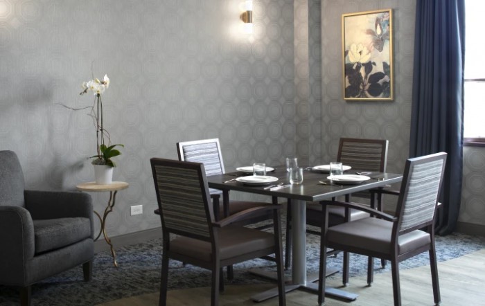 An elegant dining room setup with a modern design, featuring a table set for four.