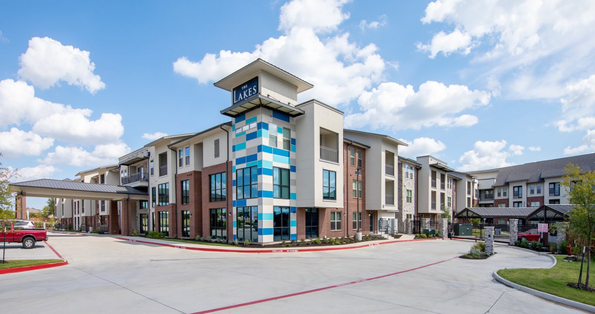 A modern apartment building with colorful accents under a partly cloudy sky.