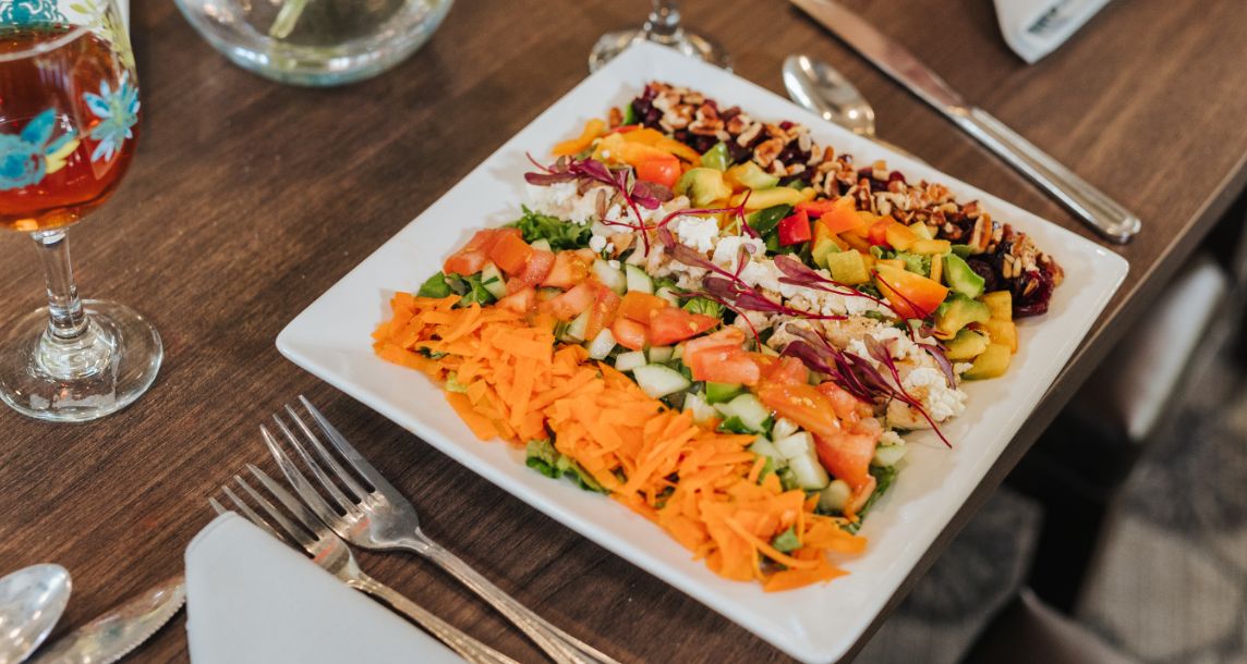 A colorful vegetable salad served on a square plate.