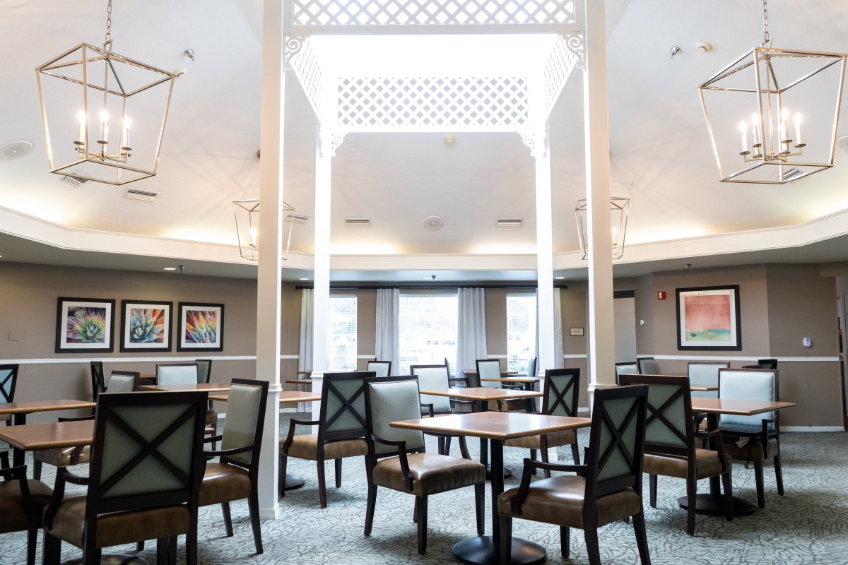 A modern dining area with neatly arranged tables and chairs, featuring elegant interior design elements.