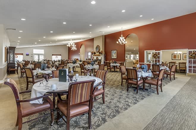 Spacious dining area with elegantly set tables and comfortable seating.