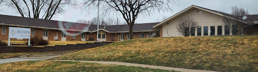 A view of a suburban house with a tree and grassy area.