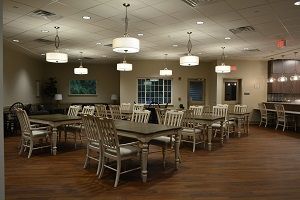A spacious and modern dining area with neatly arranged tables and chairs under soft lighting.