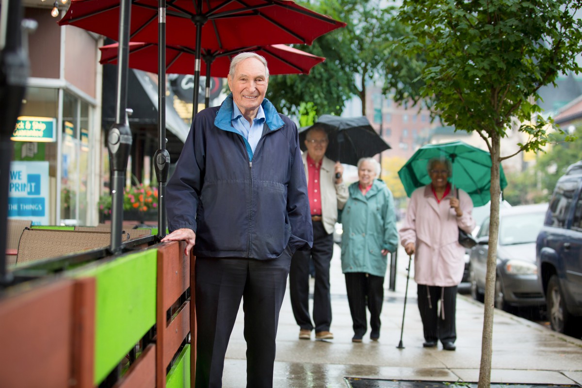 A group of people walking on a rainy street with umbrellas.