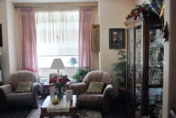 A cozy living room with soft chairs, a coffee table, and decorative elements.