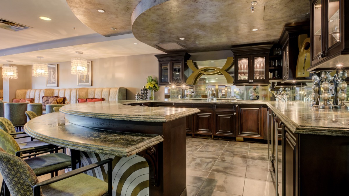 A luxurious modern kitchen with marble countertops and a stylish bar area.