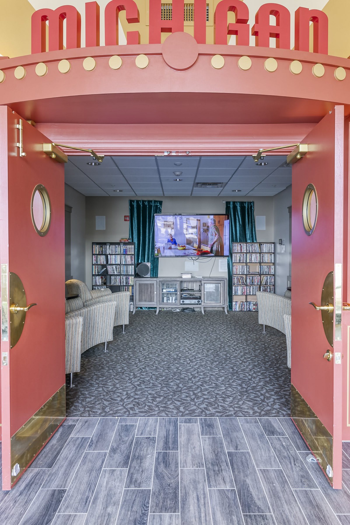An inviting library with comfortable seating, a television, and shelves filled with books.