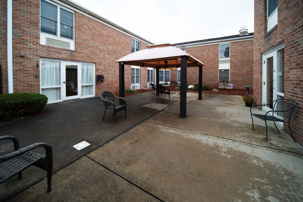 A courtyard with a gazebo and outdoor seating surrounded by a brick building.