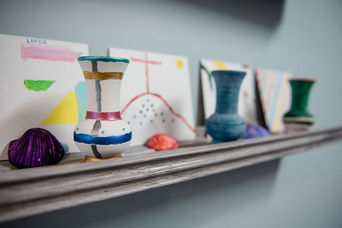 A display of colorful ceramic vases and art pieces on a shelf.