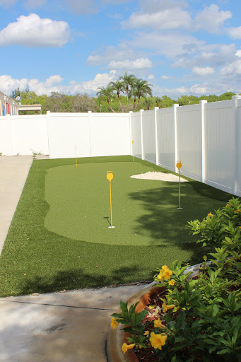 A well-maintained backyard putting green, perfect for golf enthusiasts to practice their skills.