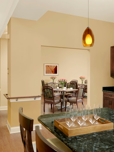 A cozy dining area visible through an archway, showcasing modern furniture and warm lighting.