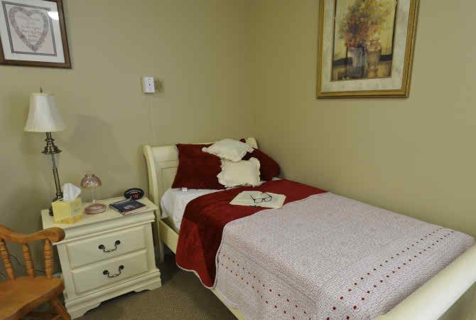 A cozy bedroom with a single bed, nightstand, and decorative items.