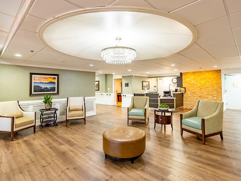 A modern lobby with comfortable seating and a central chandelier.