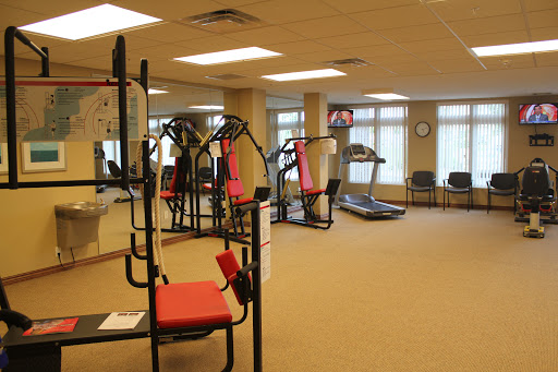 A view of a well-equipped gym featuring exercise machines and a treadmill, designed for fitness enthusiasts.