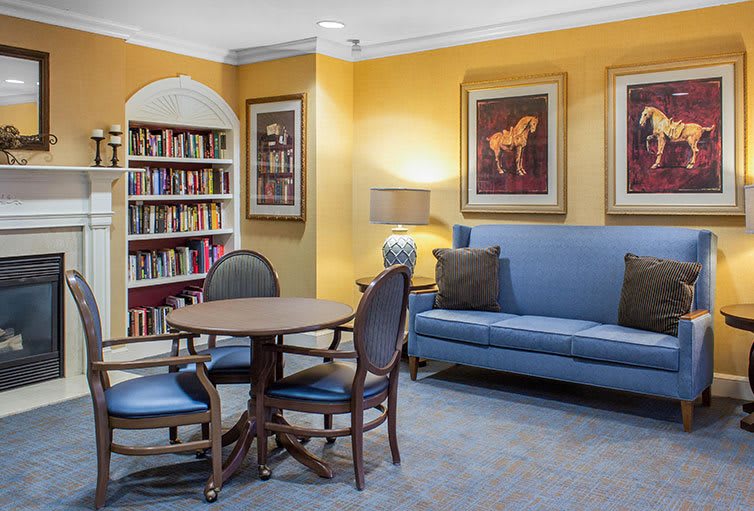 Cozy library corner with bookshelves, seating, and decorative artwork.