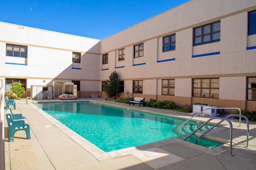 A serene swimming pool surrounded by modern architecture, perfect for relaxation on a sunny day.