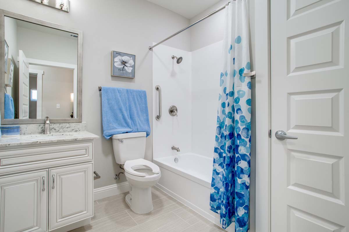 A clean and modern bathroom with a blue-themed shower curtain and towel.