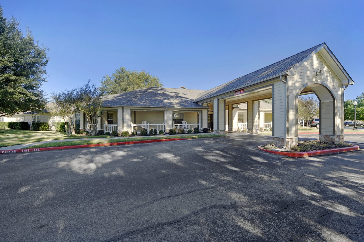 A residential building with a driveway on a sunny day.