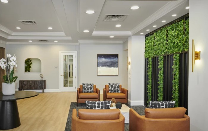 A modern lobby with comfortable seating and a green accent wall.