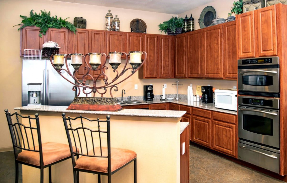 A warm and inviting kitchen with wooden cabinets, a countertop, various appliances, and decorative elements.