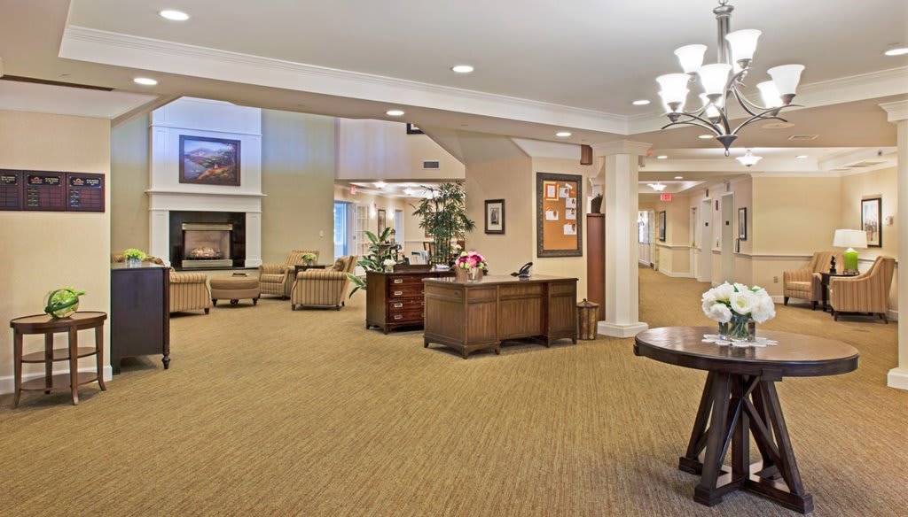 A spacious lobby area with a reception desk, comfortable seating, and elegant lighting.