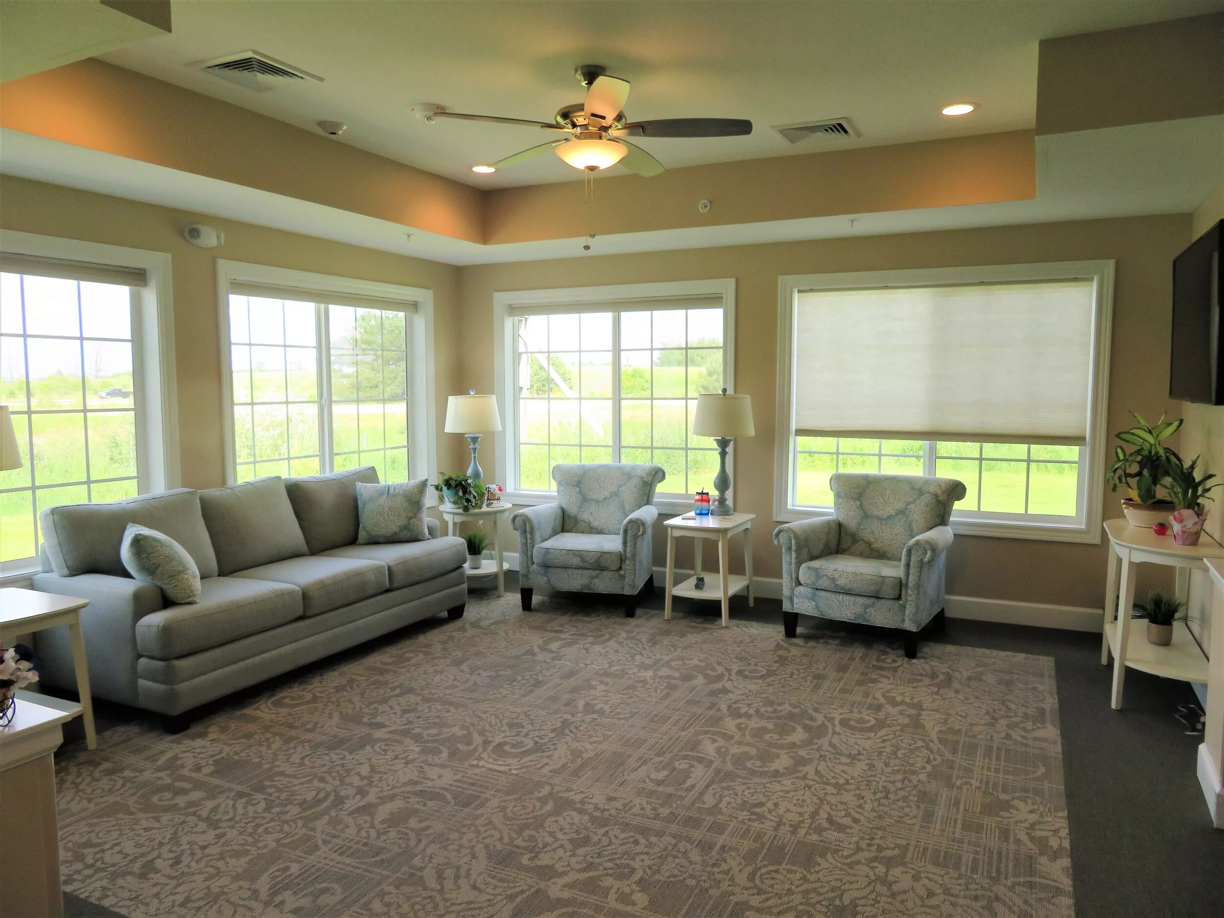A cozy living room with large windows, comfortable seating, and soft lighting.