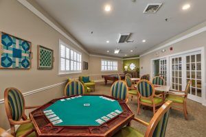 A spacious game room with a card table and comfortable seating.