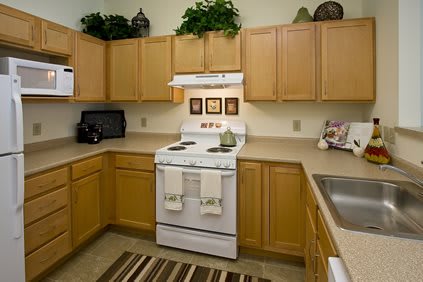 A modern kitchen with wooden cabinets and a white stove.