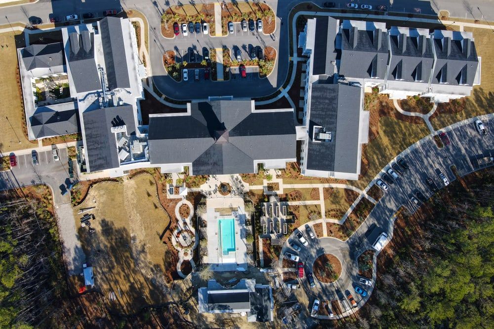 Aerial view of a complex with buildings, a swimming pool, and surrounding pathways.