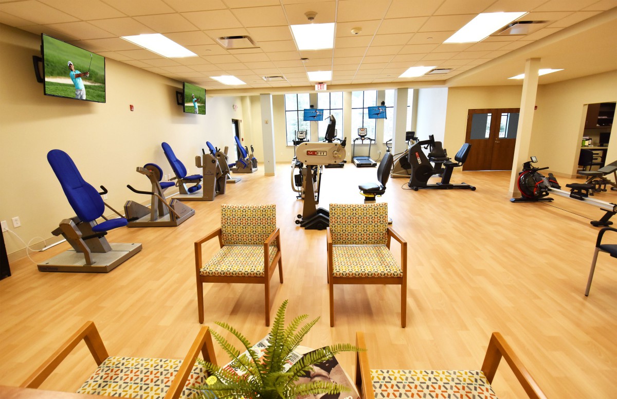 An indoor fitness center with exercise equipment and seating area.