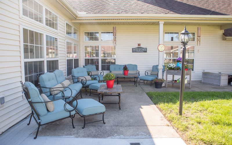 A cozy outdoor patio area featuring blue cushioned furniture and potted plants.