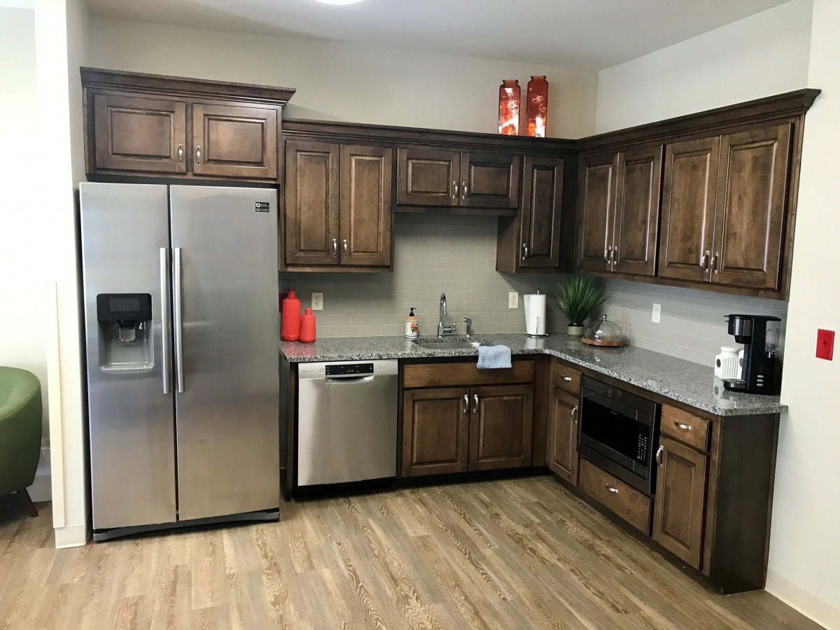A modern kitchen with wooden cabinets and stainless steel appliances.