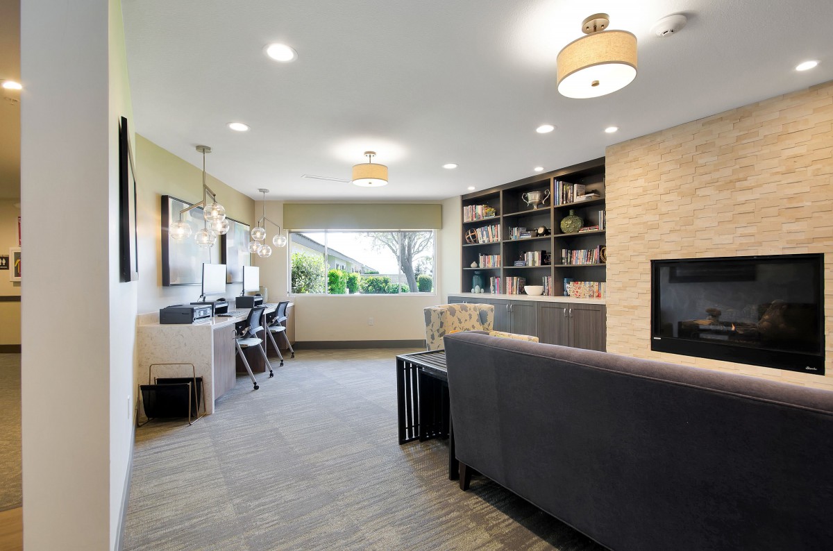 A modern living room with a dual office space and built-in bookshelves.