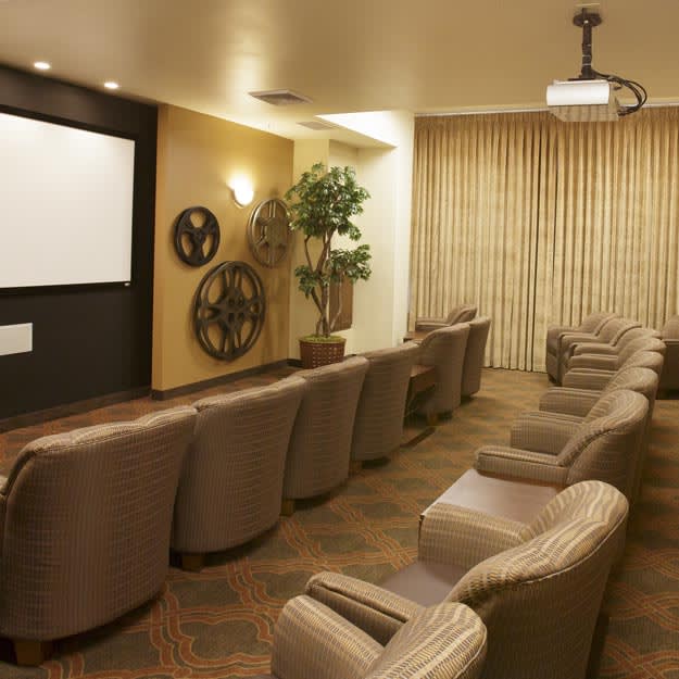 A cozy home theater room with comfortable seating and a large projector screen.