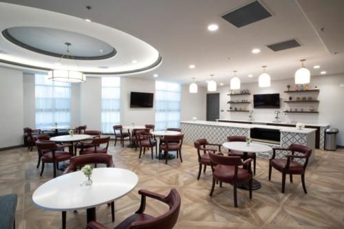 A modern cafe with elegant interior design featuring round tables and comfortable chairs.