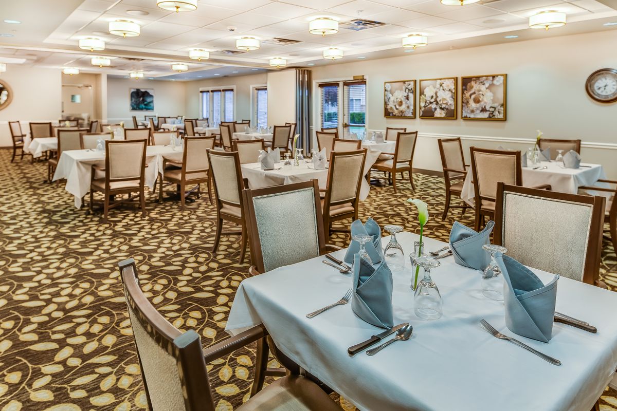 An elegant dining room with neatly arranged tables and chairs, decorated with napkins and simple decor.