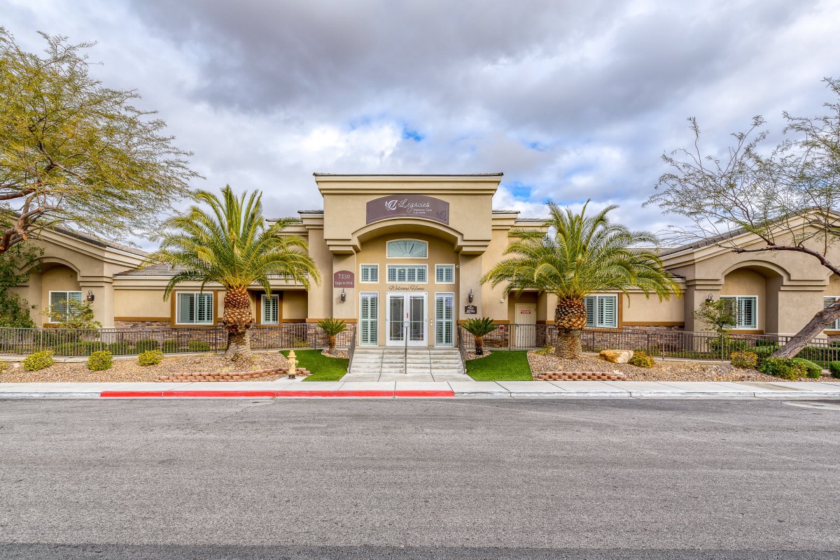 A modern building with palm trees under a cloudy sky.