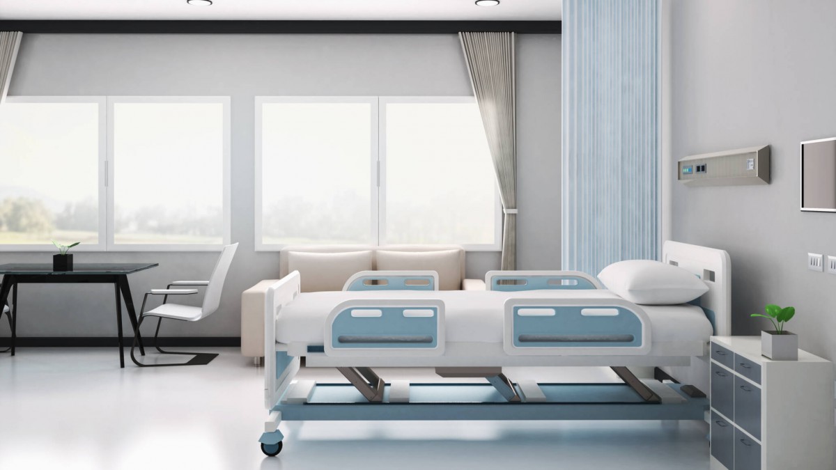 A clean hospital room with a medical bed by the window.