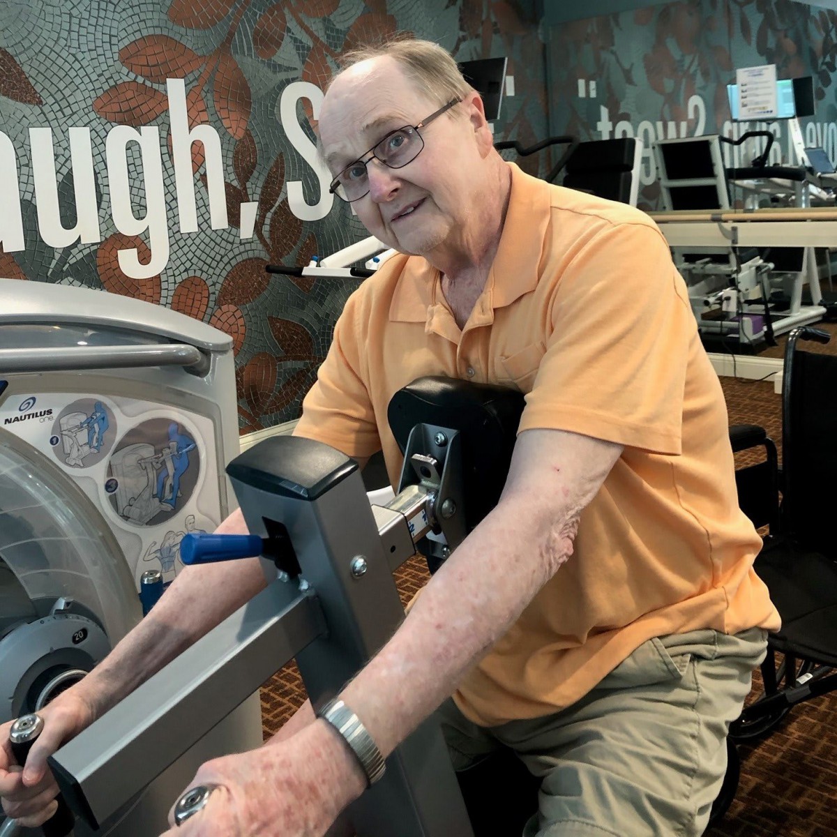 Man using exercise equipment in a gym setting.