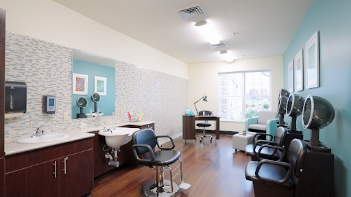 A modern and well-lit hair salon interior, featuring styling chairs and a workstation.