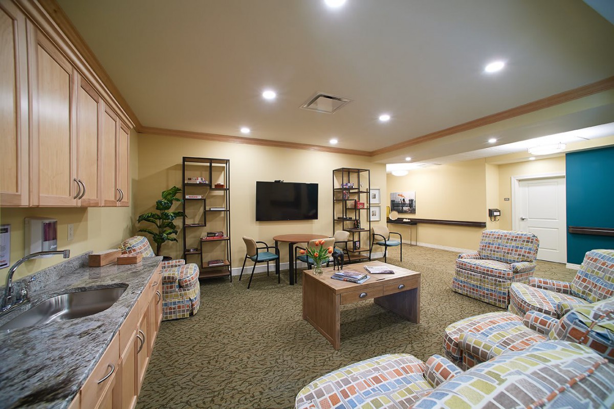 A cozy living room with armchairs, a coffee table, and a television.