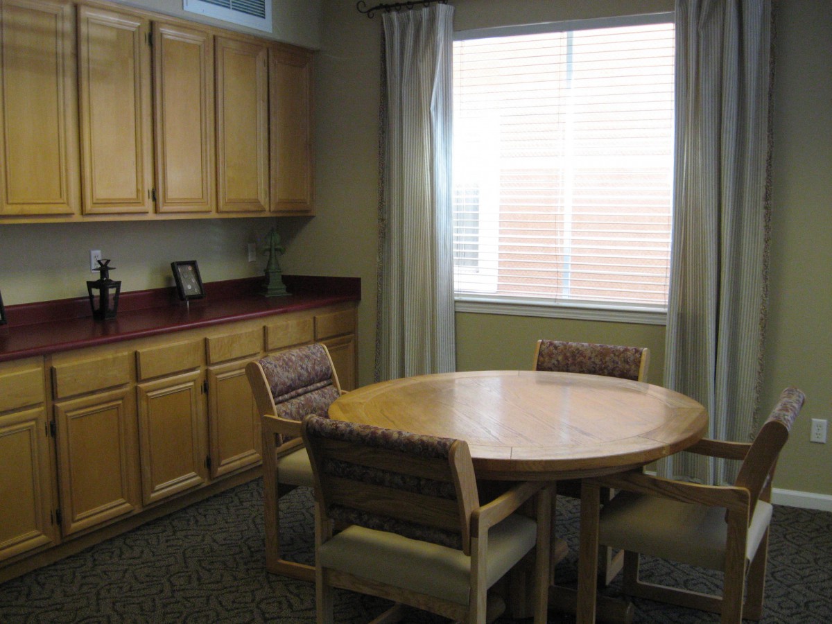 A cozy dining area with a round table, chairs, and large window.