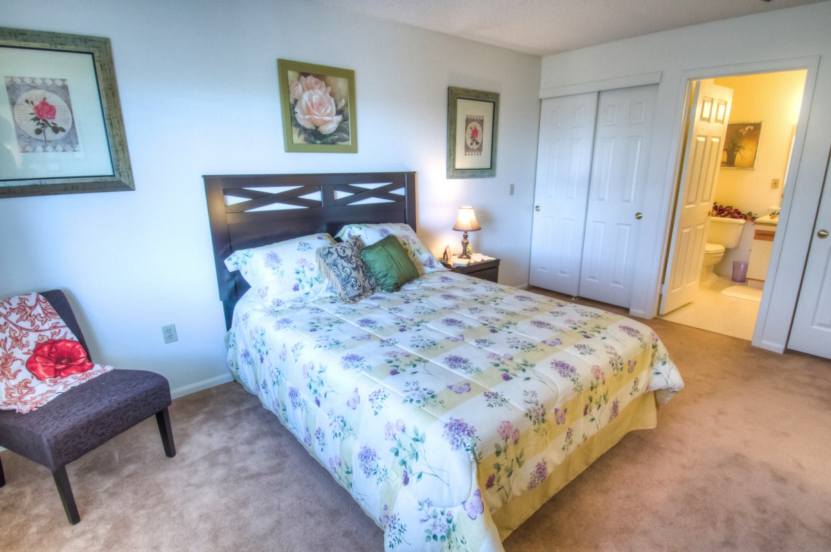 A cozy bedroom with floral bedding and minimalist decor.